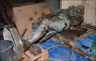 Foto van het met verf besmeurde Colston-standbeeld, liggend op pallets.